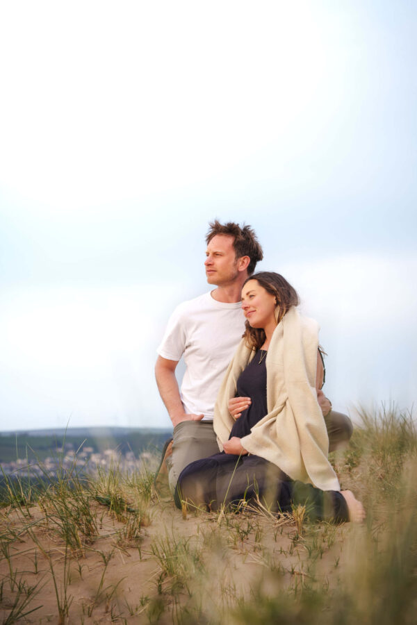 Family portrait of Fi and Freddy on a beach, sharing an intimate, natural moment in soft light.