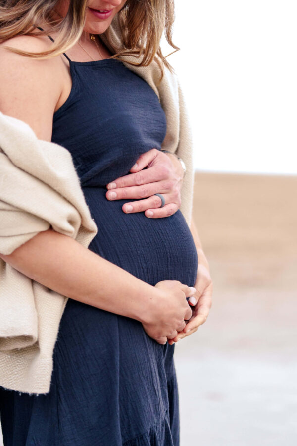 Family portrait of Fi and Freddy on a beach, sharing an intimate, natural moment in soft light.