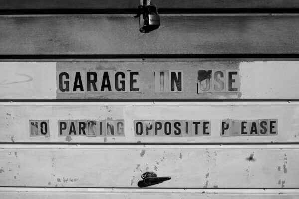Bristol Street photography - High contrast Black and white images garage door says "Garage in use, no parking opposite." Please artistic.