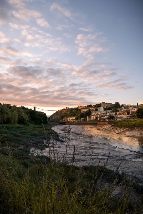 Clifton Suspension Bridge and River Avon at dusk, pink and blue sky above a wildflower foreground