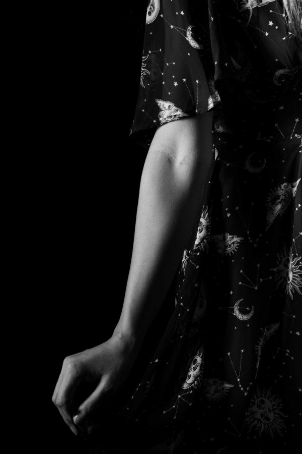 Black and white portrait, arm and chest artistically positioned.