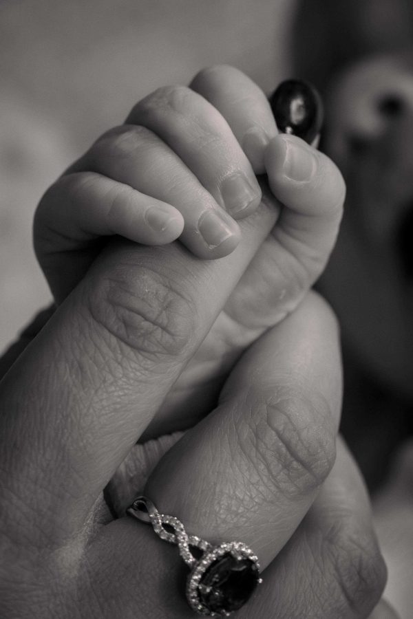 Baby holding mother's hand.